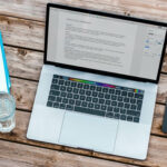 MacBook mit Arbeitsutensilien