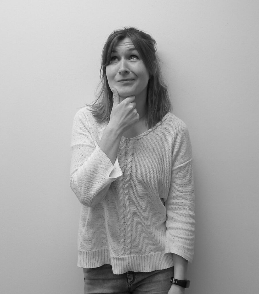 Frau in weißem Oberteil macht ein nachdenkliches Gesicht