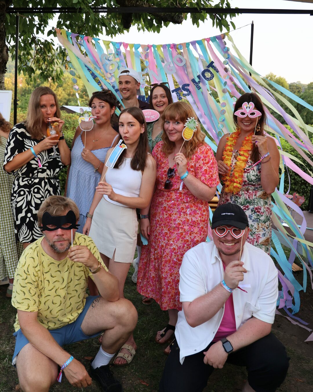 Somengos machen ein Gruppenfoto mit lustigen Fotoelementen vor ihren Gesichtern