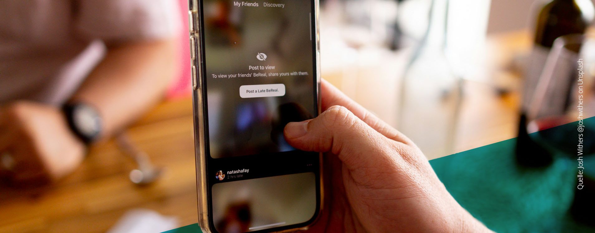 Nahaufnahme von einer Hand, die mit einem Smartphone ein Foto mit der BeReal-App macht