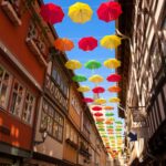 Symbolisches Bild der Erfurter Krämerbrücke mit bunten Regenschirmen geschmückt: Somengo feiert die neue Partnerschaft als Kreativpartner der Thüringer Tourismus GmbH