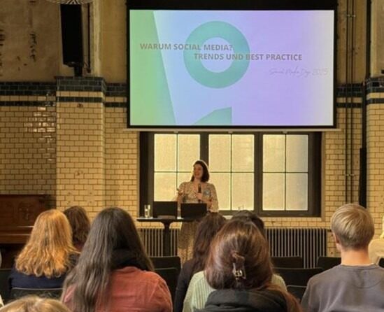 Mitarbeiterin der Somengo als Speakerin auf einer Bühne vor Publikum