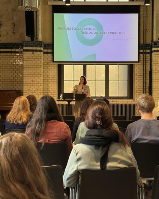 Mitarbeiterin der Somengo als Speakerin auf einer Bühne vor Publikum